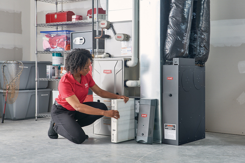 CMR Mechanical worker replacing an air filter in a furnace/home heating unit