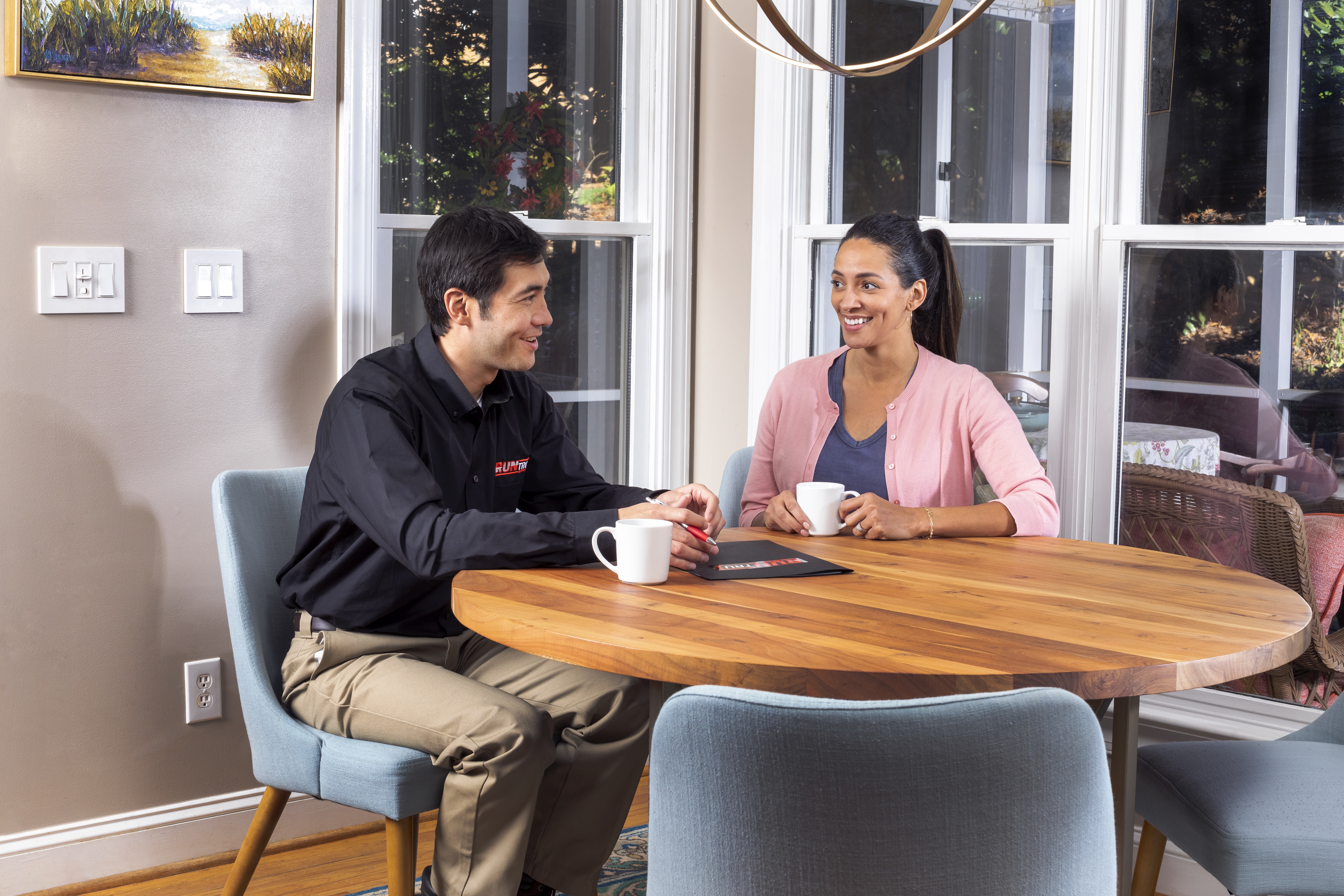 Technician speaking with customer in a home serviced by CMR Mechanical.
